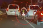 Motosiklet sürücüsü trafikte kaskı başına takması yerine arkasına bağladı