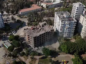Adana’da yaklaşık 33 yıl önce inşaatına başlanan 11 katlı bina, damına iş makinesi çıkartılarak yıkılıyor
