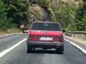 Ayaklarını camdan sarkıtarak trafiği tehlikeye attı

