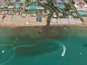 Dereden gelen sular denizi kahverengiye bürüdü, turistler sahili boşalttı
