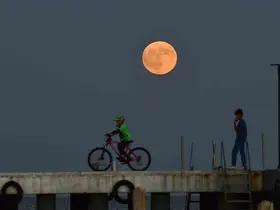 Dolunay ile insanların siluetleri aynı karede
