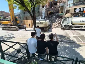 Yıkım çalışmalarını keyifle izleyen gençler
