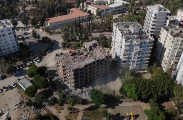 Adana’da yaklaşık 33 yıl önce inşaatına başlanan 11 katlı bina, damına iş makinesi çıkartılarak yıkılıyor 