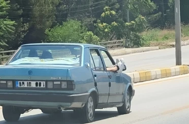 Ayaklarını camdan dışarı çıkartan yolcu trafiği riske attı 