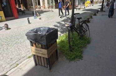 Çöp kutusunun hemen yanındaki bisikletin sepeti atıklarla doldu 