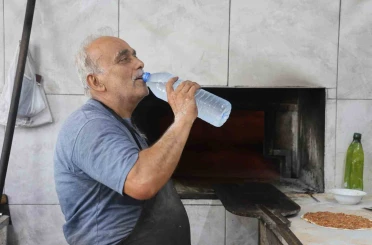 Kavurucu sıcakta ocak başında zorlu mesaiyi sürdüren fırıncılar günde 5 litreyi bulan su tüketiyorlar 