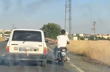 Otoyolda tehlikeli yolculuk: Motosiklet, otomobil kemerine tutunarak ilerledi 