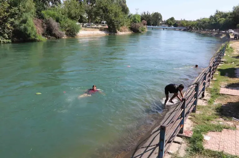 Kavurucu sıcakta hem kanalda yüzdüler hem karpuz yediler

