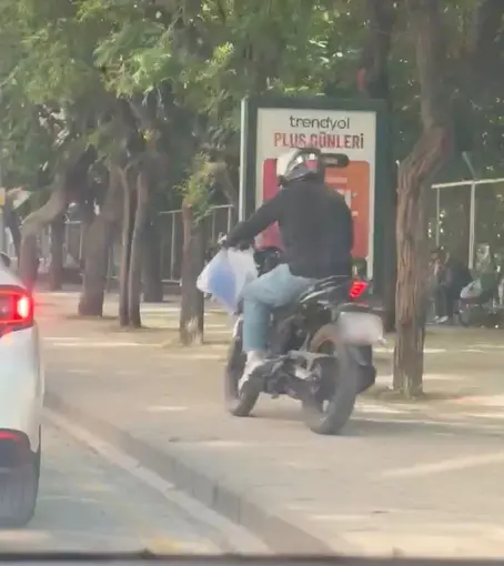 Trafiği beklememek için kaldırımdan yoluna devam etti

