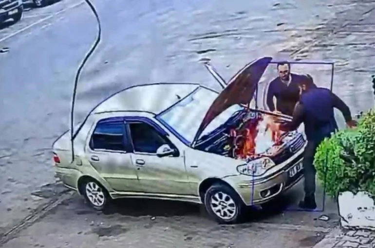 Alev alan otomobili üfleyerek söndürmeye çalıştı: O anlar kamerada