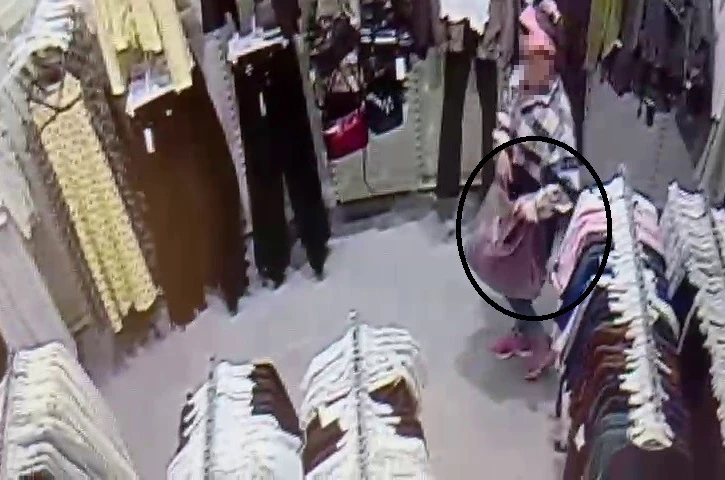 Alışveriş merkezinde çocuğunun yanında hırsızlık yapan kadın kamerada