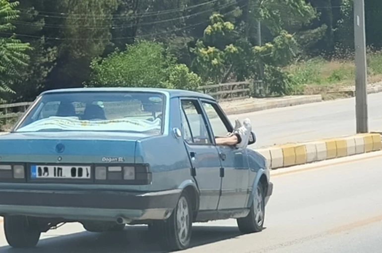 Ayaklarını camdan dışarı çıkartan yolcu trafiği riske attı