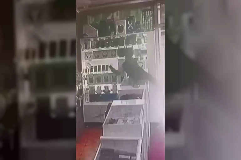 Böyle hırsızlık görülmedi: Masanın üstüne çıkıp vitrindeki telefonları alarak kaçtı