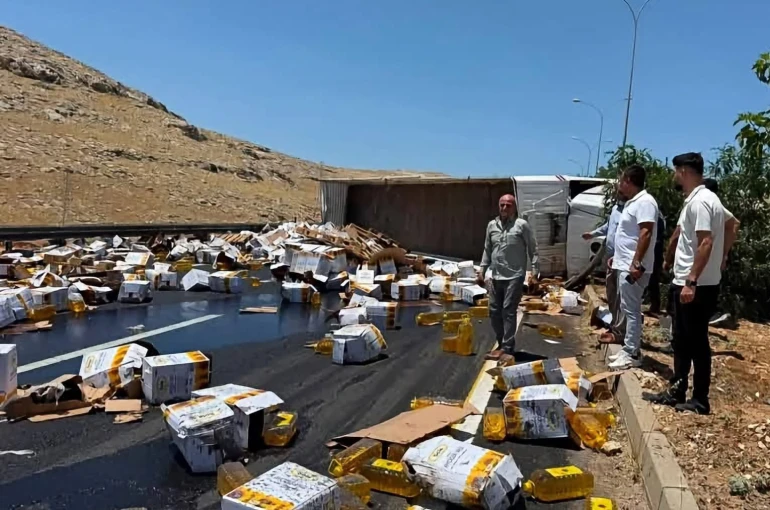 Devrilen tırdaki yağ bidonları yola savruldu
