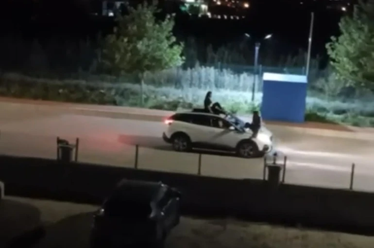İki kadının seyir halindeki otomobilin üstünde tehlikeli yolculuğu kamerada