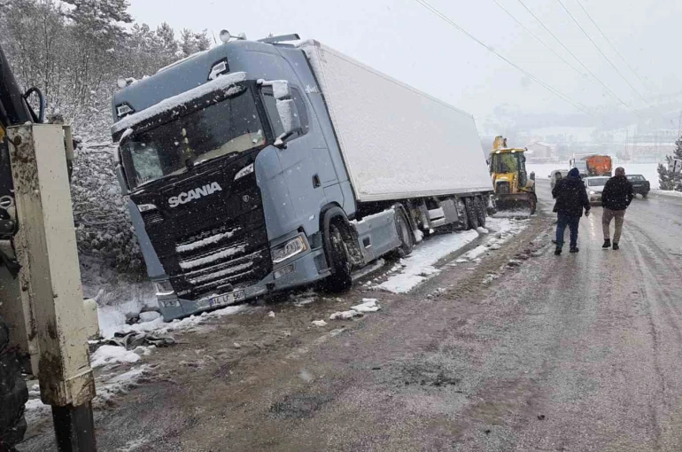 Karlı yolda, tır şarampole devrildi