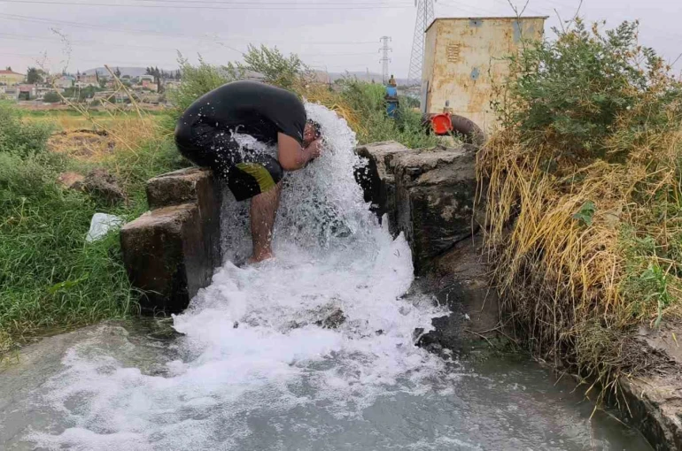 Kavurucu sıcakta elbisesini bile çıkarmadan buz gibi sondaj suyunda serinledi