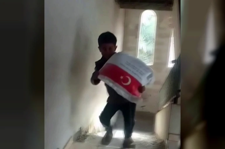 Kendi ağırlığı kadar un çuvalını taşıyan Filistinli çocuğun sevinci