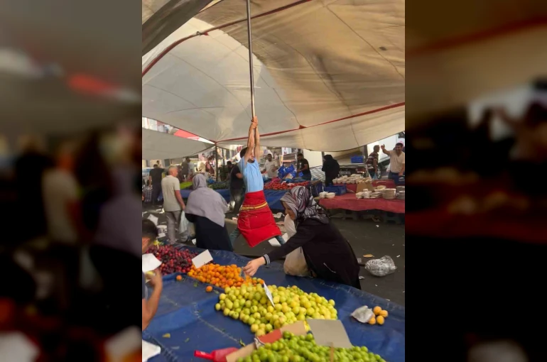 Kuvvetli rüzgarda pazarcı branda direğini bırakmadı, metrelerce havaya yükseldi
