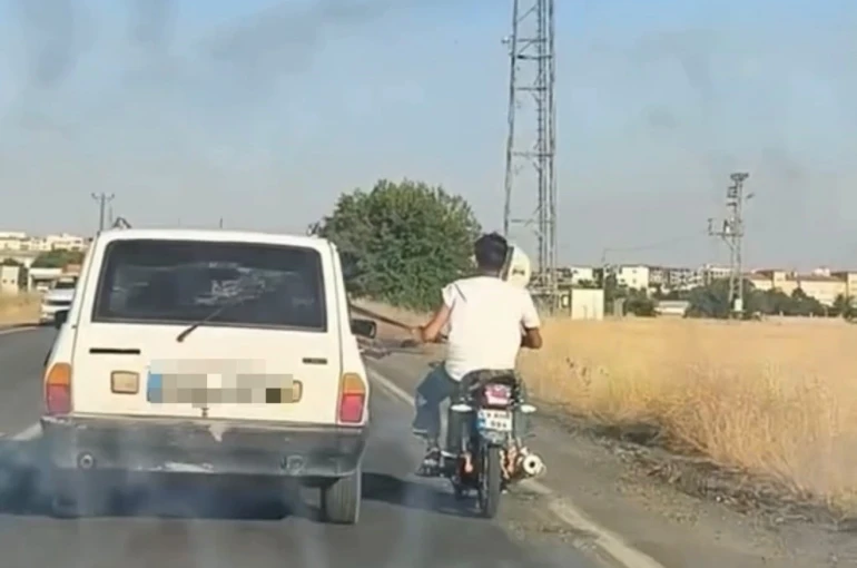 Otoyolda tehlikeli yolculuk: Motosiklet, otomobil kemerine tutunarak ilerledi
