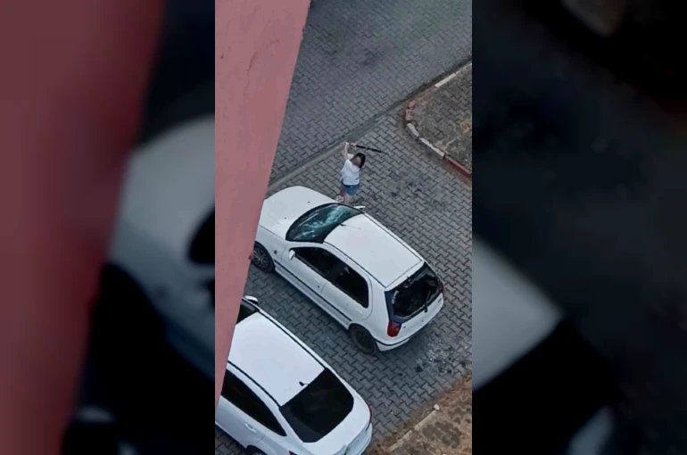 Park halindeki otomobilin camlarını kıran kadın kamerada