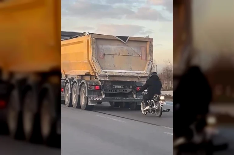 Seyir halindeki tırın peşinde motosikletli tehlikeli yolculuk