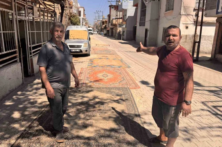 Tozdan bunalan mahalleli çareyi sokağa halı sermekte buldu