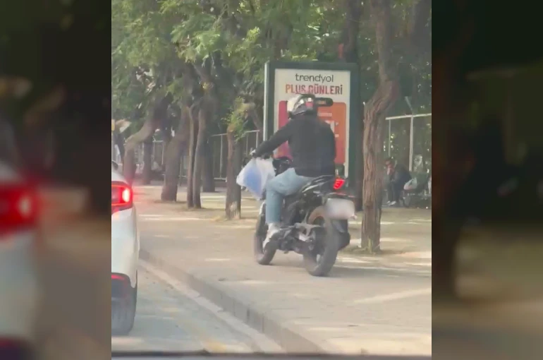 Trafiği beklememek için kaldırımdan yoluna devam etti
